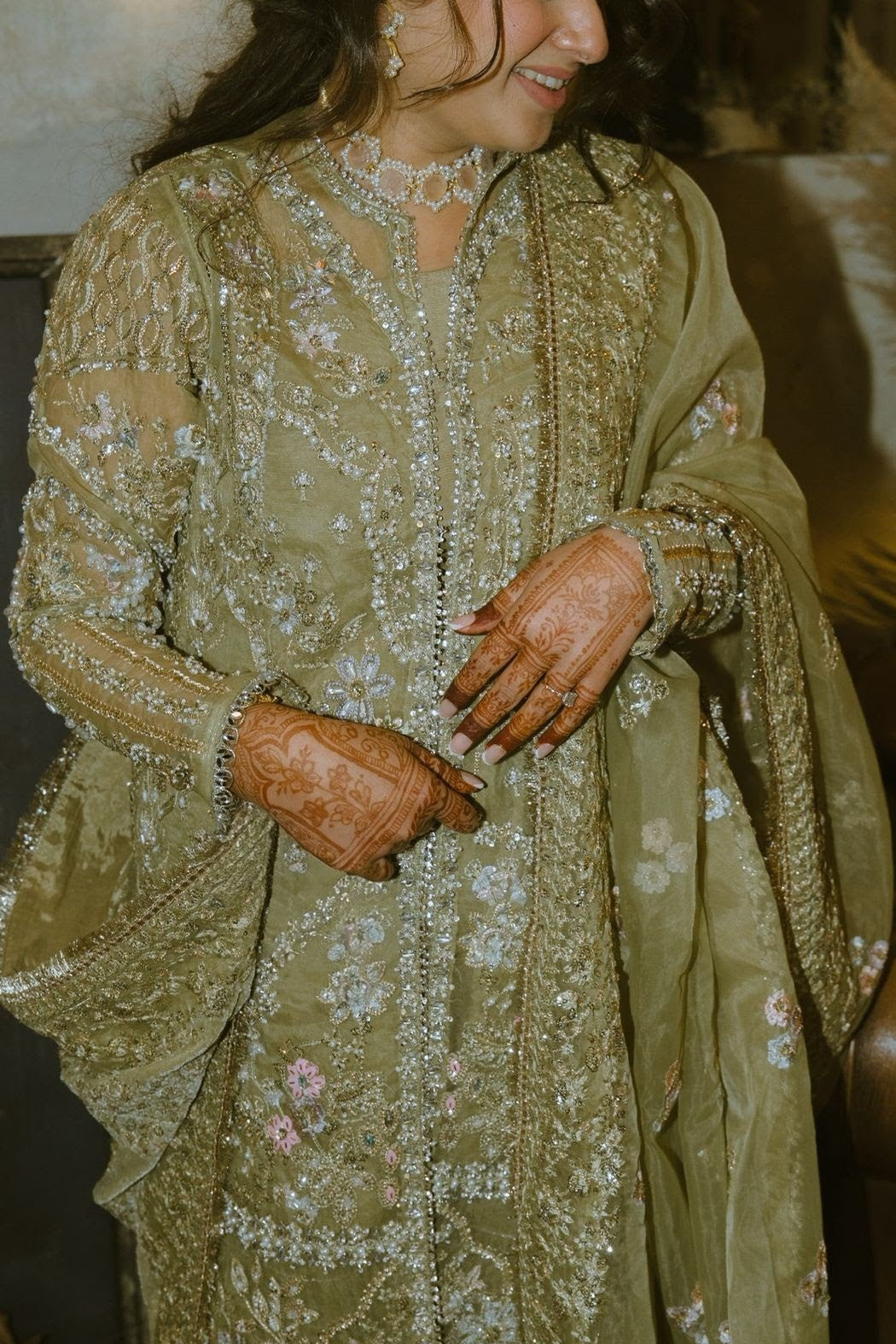 A beautiful woman wearing a green pakistani outfit with a pink choker jewellery set from Roya Jewellery
