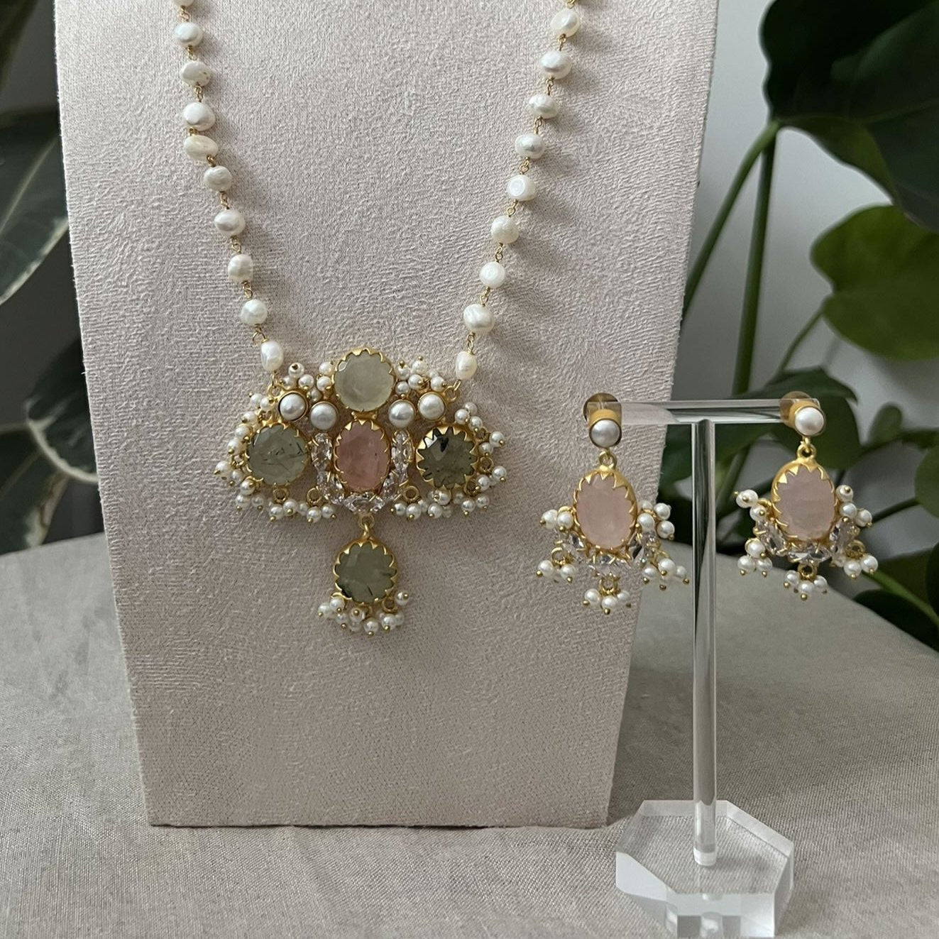 Indian jewelry set in rose quartz, with a pearl mala necklace, cloudy pink earrings surrounded by pearl clusters.