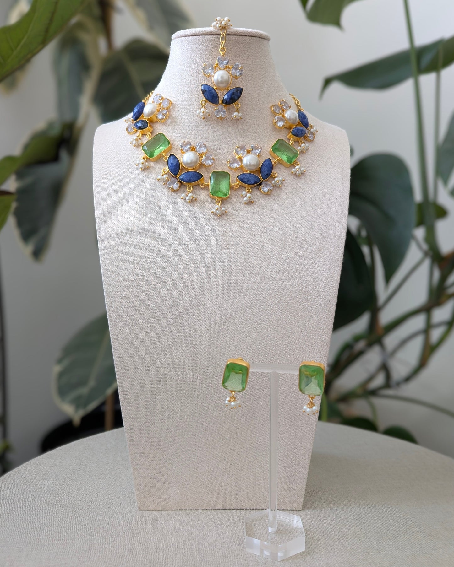 Jewelry set with necklace and earrings on a mannequin bust against a natural background