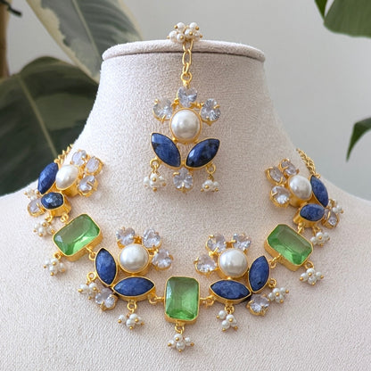 Jewelry set with necklace and earrings on a mannequin bust against a plant background