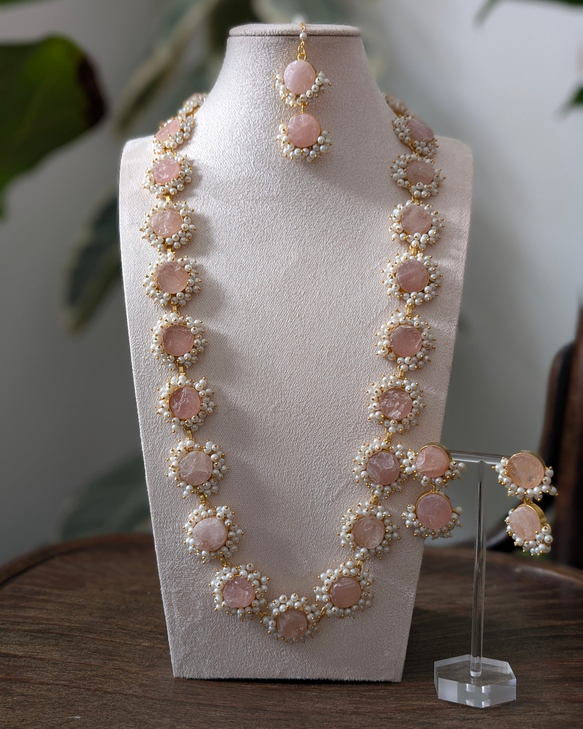 Necklace and earrings set on a mannequin bust with a blurred background