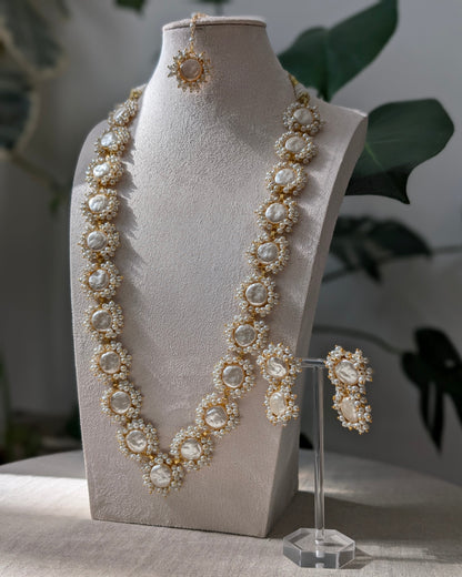 Pearl necklace and earrings on a mannequin bust with a blurred background