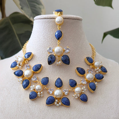 Jewelry set with necklace and earrings on a mannequin bust against a natural background