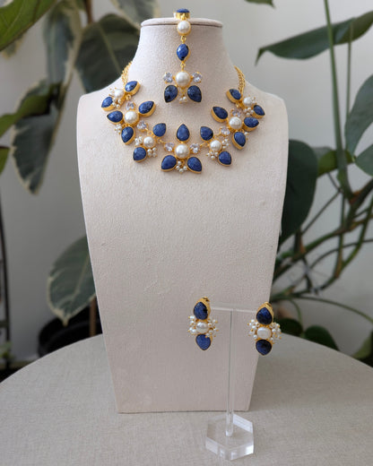Jewelry set with necklace and earrings on a mannequin bust against a natural background