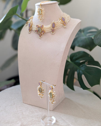 Jewelry set on a mannequin bust with a plant in the background