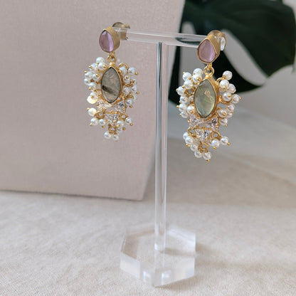 Pair of earrings on a clear stand with a neutral background