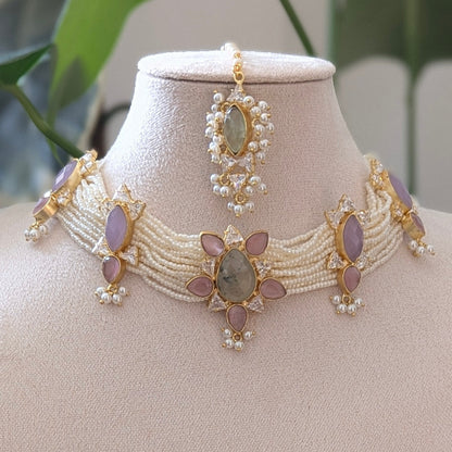 Jewelry set on a mannequin bust with green leaves in the background