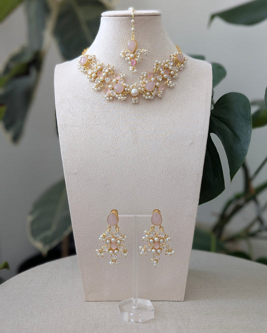 Jewelry set with necklace and earrings on a mannequin bust against a neutral background.