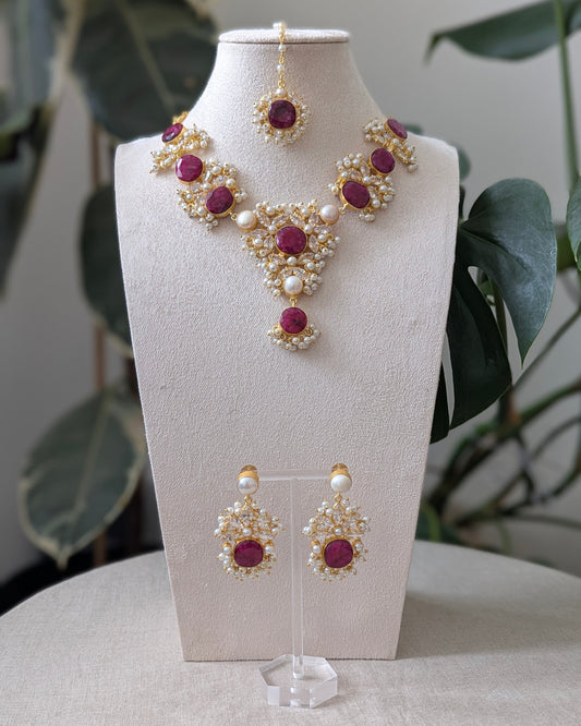 Jewelry set with necklace and earrings on a mannequin bust against a neutral background