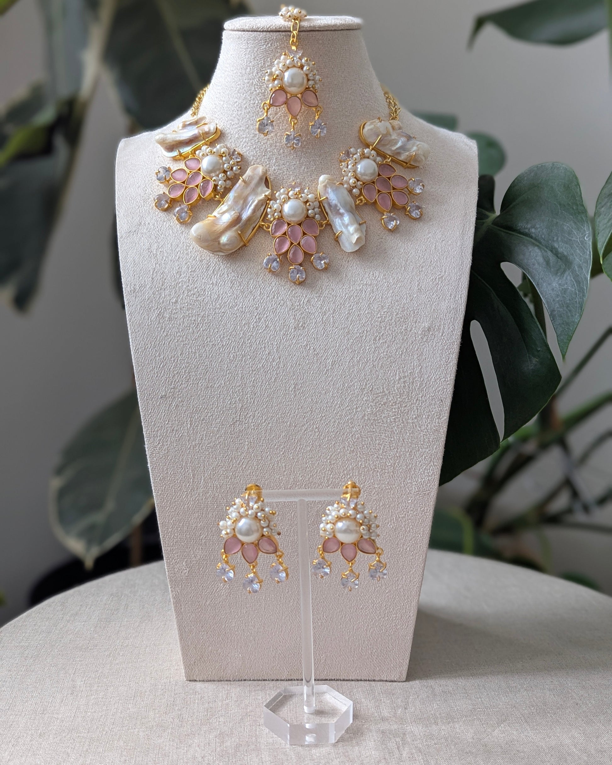 Jewelry set with necklace and earrings on a mannequin bust against a neutral background