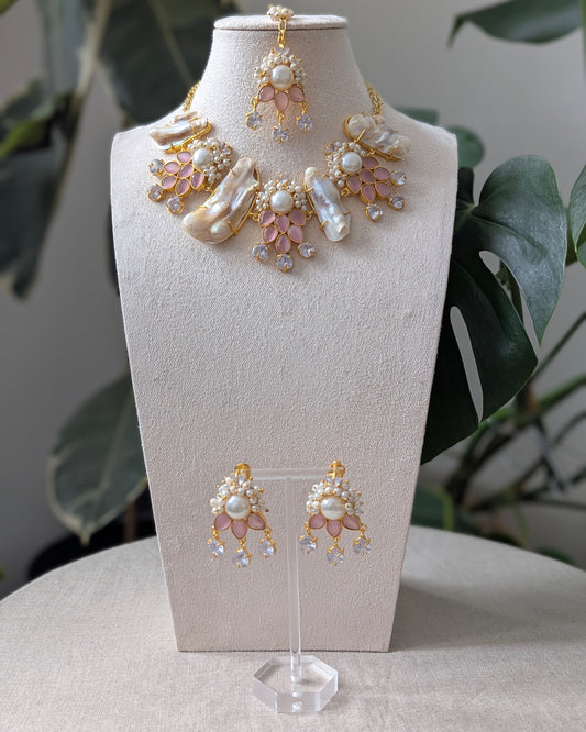Jewelry set with necklace and earrings on a mannequin bust against a neutral background