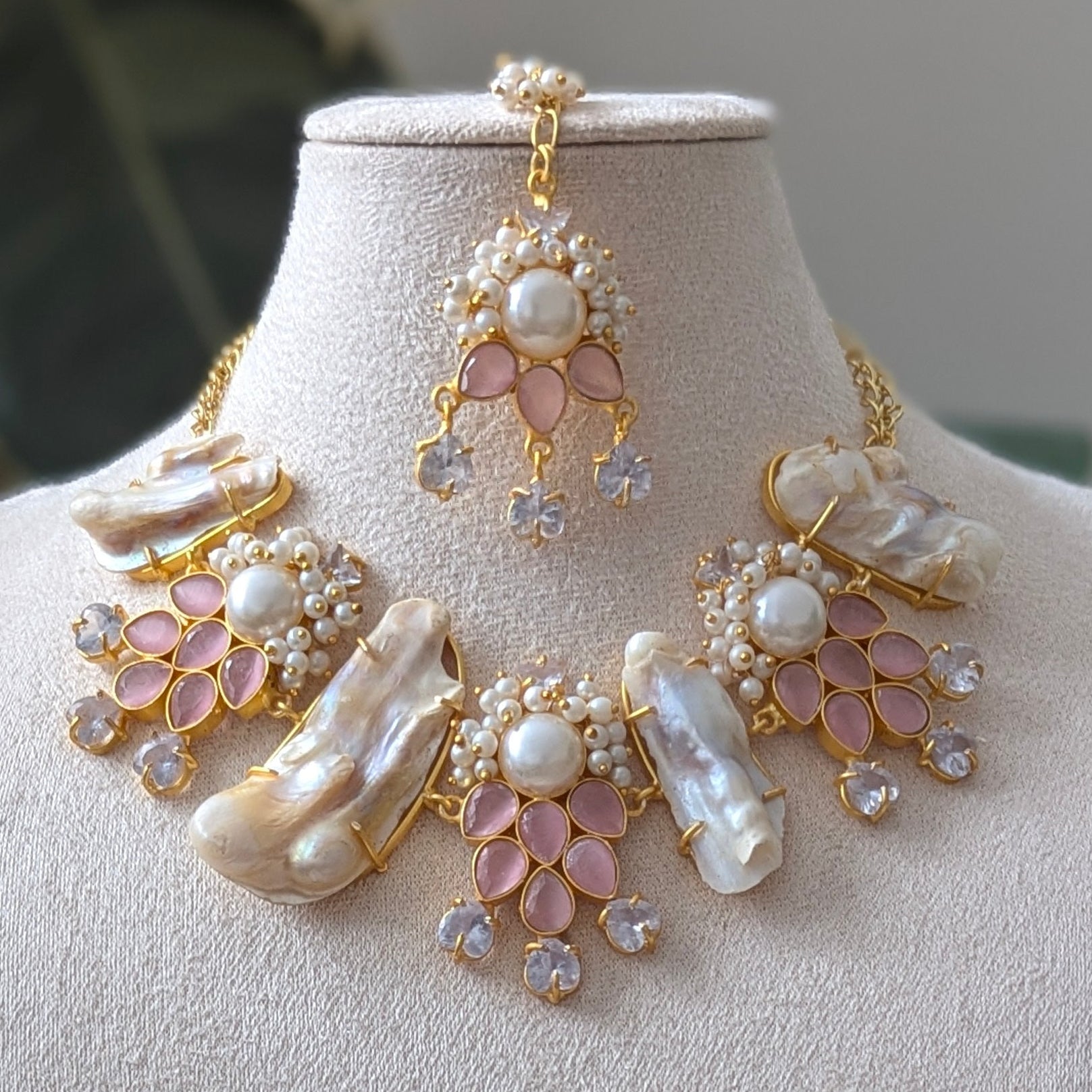 Jewelry set with necklace and earrings on a mannequin bust against a neutral background